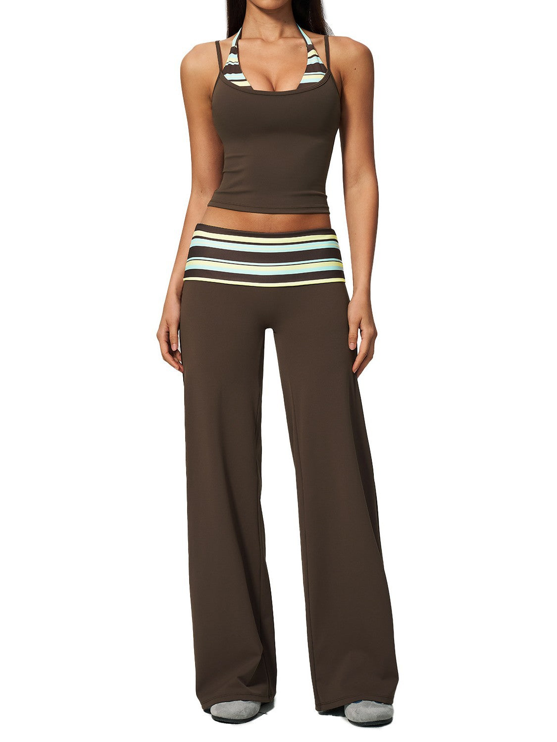 A woman modeling a matching two-piece lounge set consisting of a brown cropped tank top with striped halter straps and matching wide-leg pants with a striped waistband.